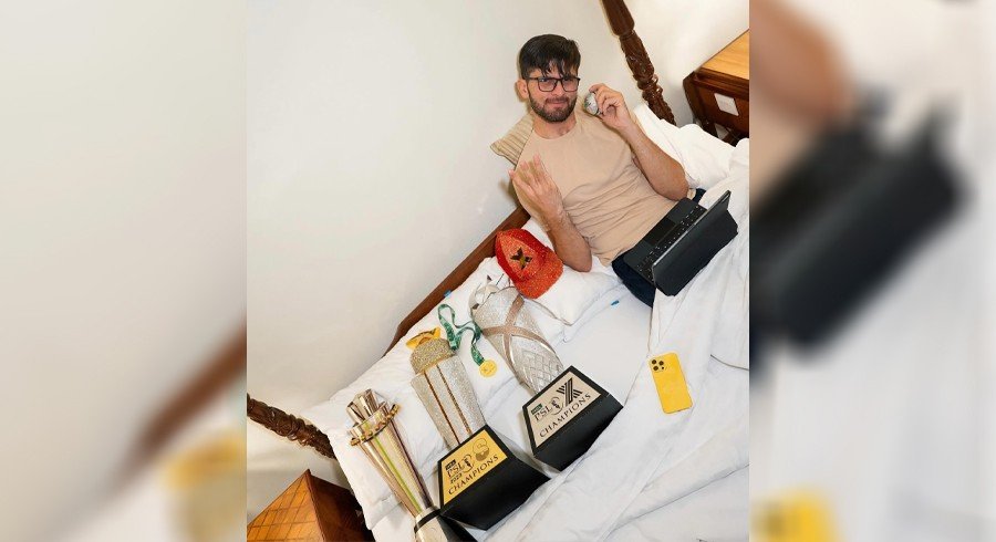 Shaheen Afridi celebrating on the field, holding the PSL trophy high with jubilant teammates in the background
